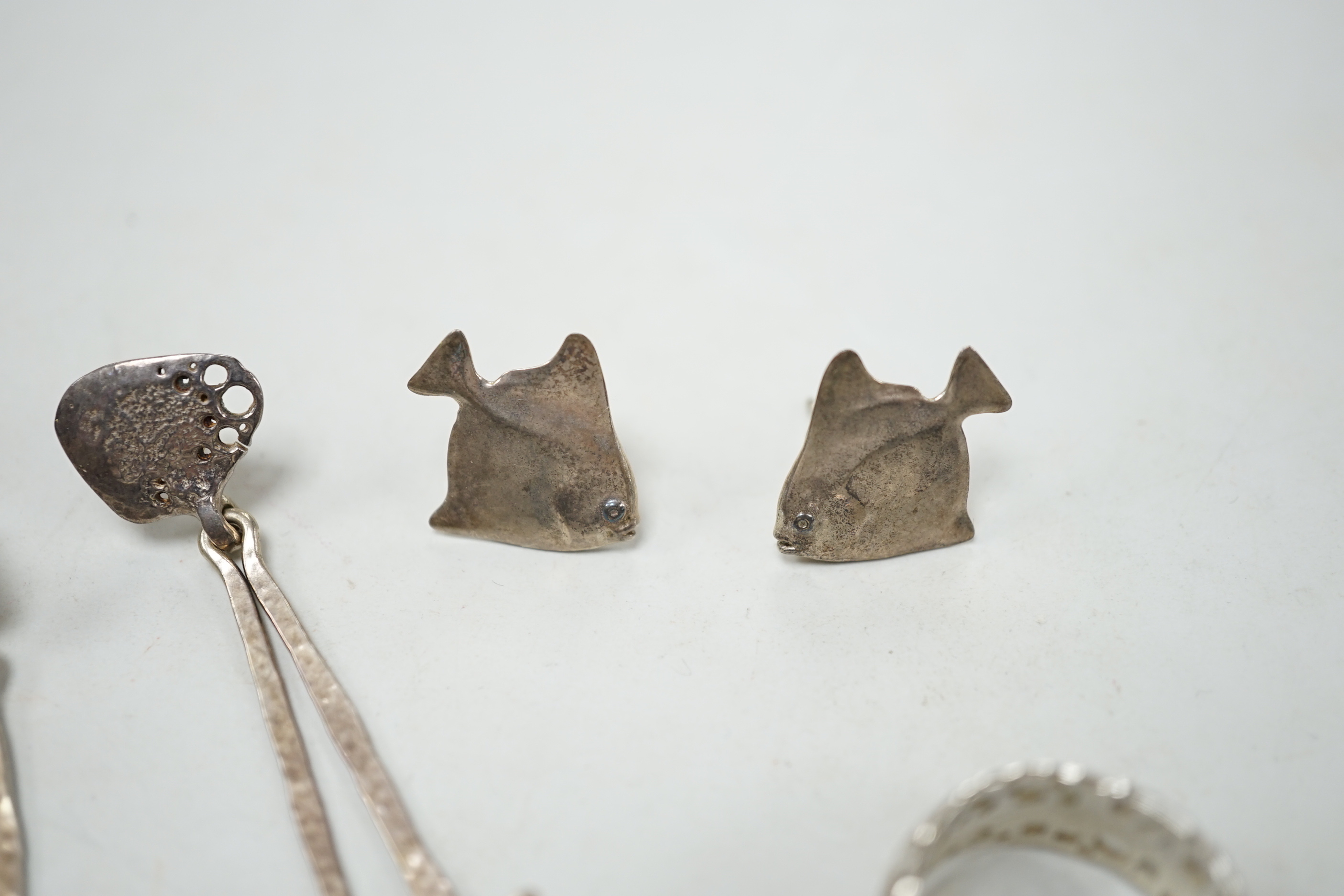 A modern Alan Vallis parcel gilt silver ring, with starfish motif, size O and two pairs of Alan Vallis silver earrings, both modelled with fish, longest overall 74mm.